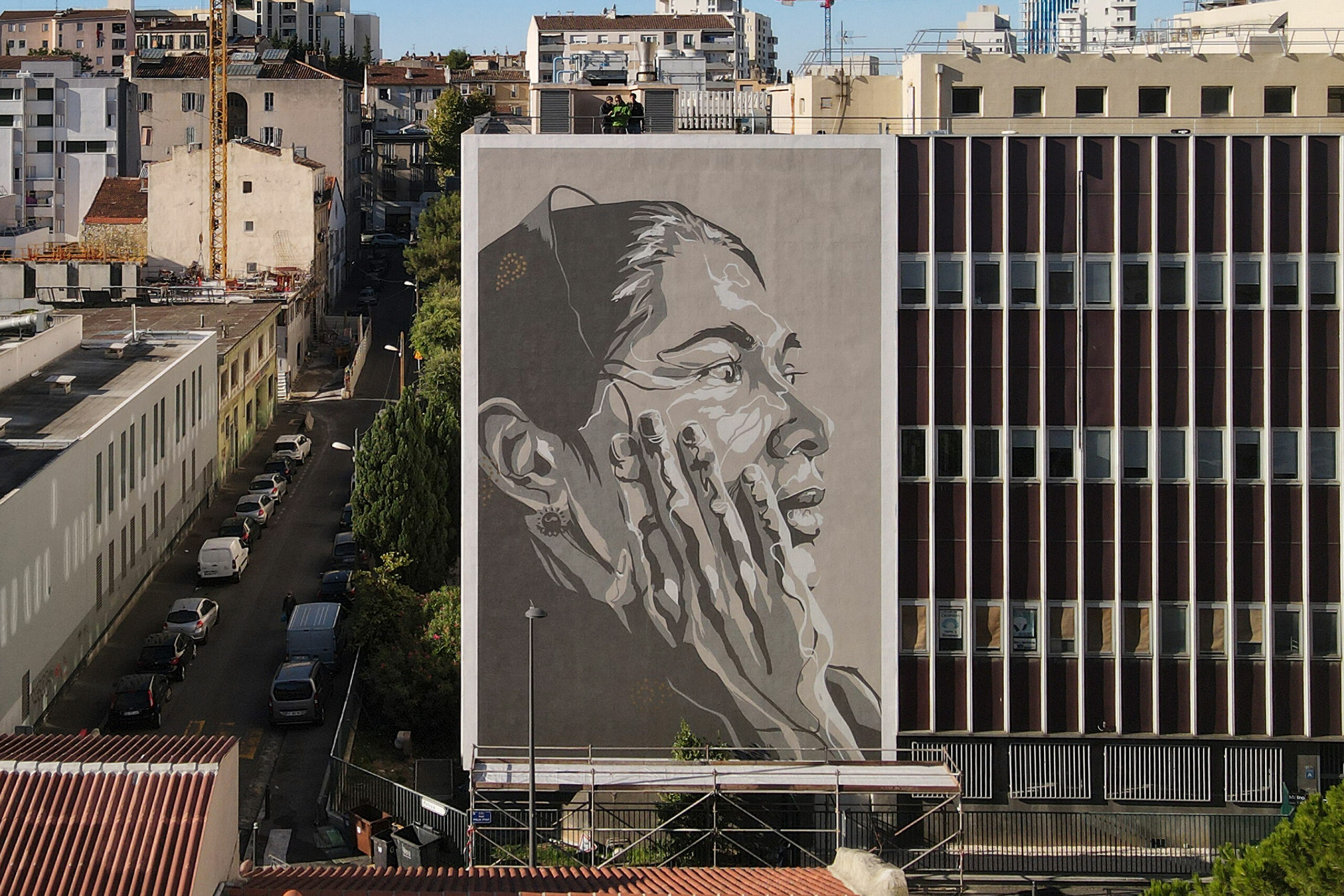 A large mural of a man smoking on the side of a building